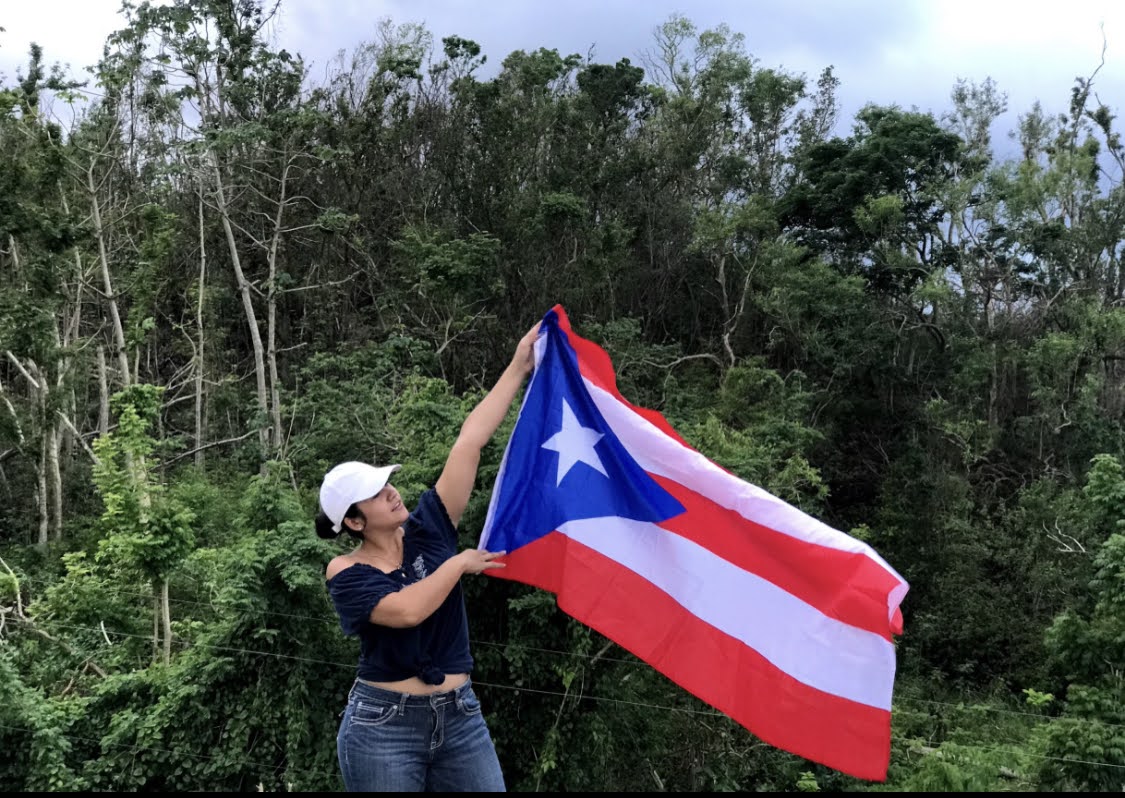 Artist holding up a Puerto Rican flag