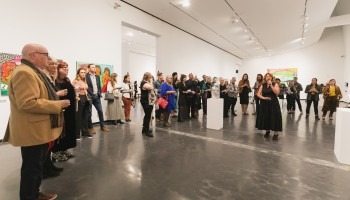 A crowd gathers in a gallery.