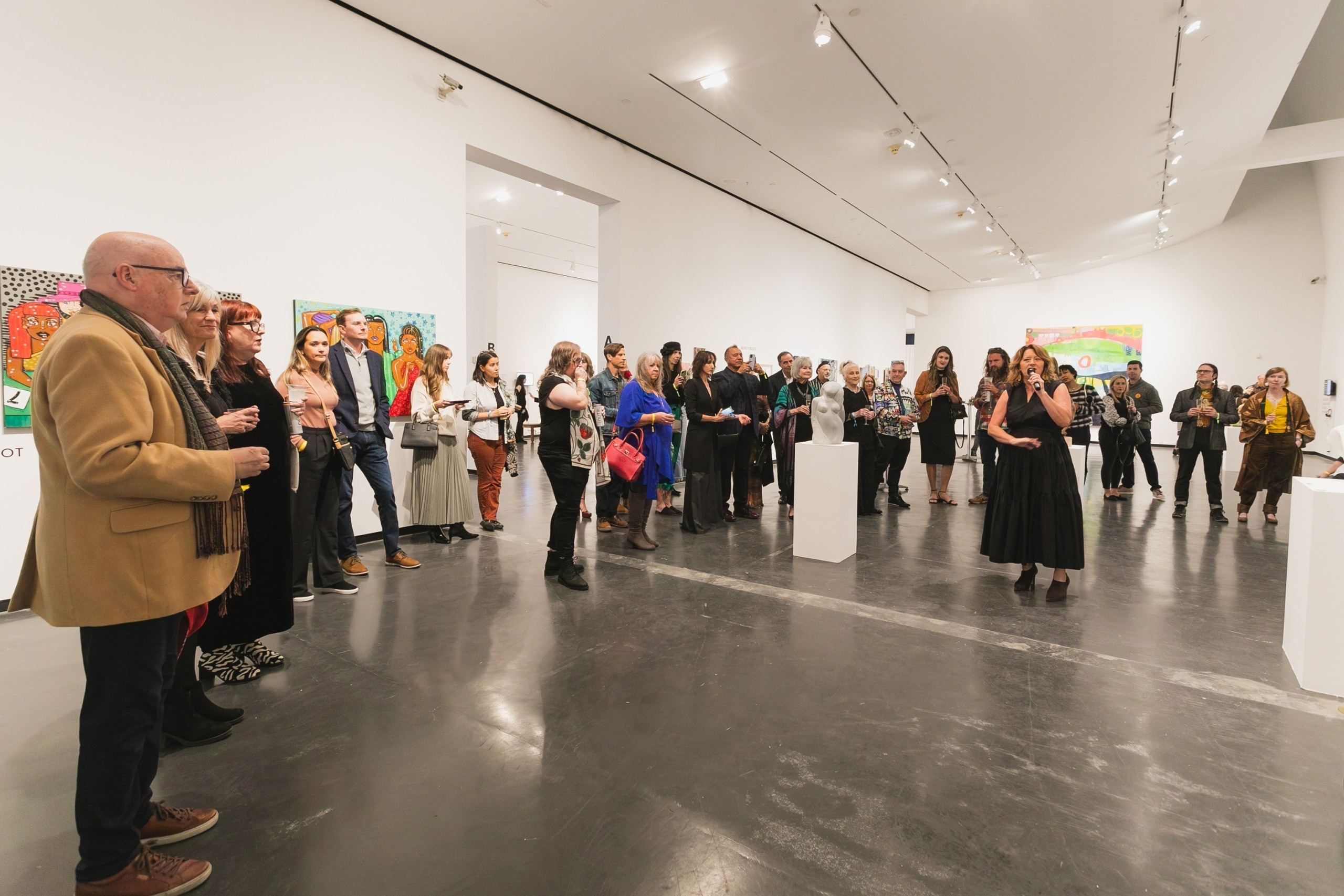 A crowd gathers in a gallery.